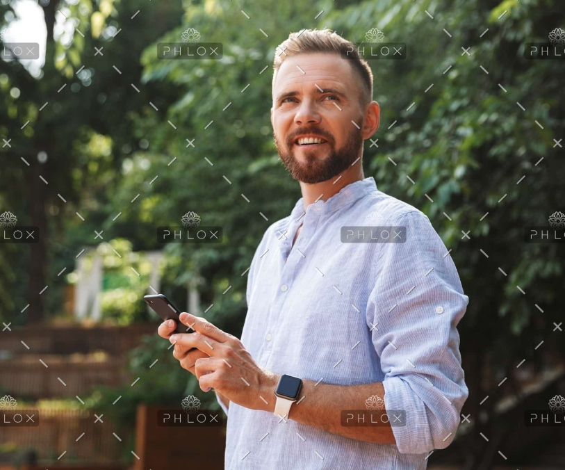 demo-attachment-437-op_happy-young-bearded-man-outdoors-using-mobile-B9D43PN